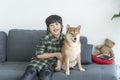 The boy cuddling with a Shiba Inu on the sofa in the living room