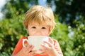 Boy with a cup. Happy healthy baby. Happy childhood in nature.