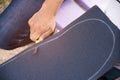 Boy cuts the griptape on a skateboard Royalty Free Stock Photo