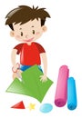 Boy cutting color papers with scissors