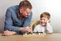 Boy with dad playing checkers at home Royalty Free Stock Photo