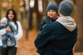 Boy is on the dad's hands. Father with his son on hands walking with mother that is with toddler Royalty Free Stock Photo