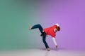 Boy dancing hip-hop in stylish clothes on gradient background at dance hall in neon light. Royalty Free Stock Photo