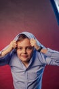 The boy is dark in a blue shirt on a purple and maroon background Royalty Free Stock Photo