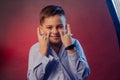 The boy is dark in a blue shirt on a purple and maroon background Royalty Free Stock Photo