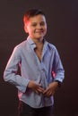 The boy is dark in a blue shirt on a purple and maroon background Royalty Free Stock Photo