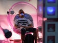 Boy with Dark Glasses sitting inside a Pink Circular Hemisphere for Medical Treatment to the teeth