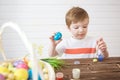 Boy decorate easter egg. A little boy painting and decorating Easter eggs. Portrait of cute boy 3 years old. He holds