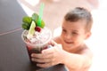 Boy with delicious refreshing drink, focus on plastic cup Royalty Free Stock Photo