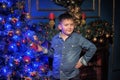 Boy in a denim shirt against of the Christmas tree Royalty Free Stock Photo