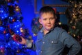 Boy in a denim shirt against of the Christmas tree Royalty Free Stock Photo