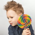 A boy in a denim shirt eating lollipop. Royalty Free Stock Photo