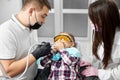 Boy in dental chair closes mouth with hands, fearing dentist Royalty Free Stock Photo