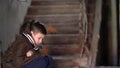 Boy in depression, hiding from the cold in an old dilapidated house Royalty Free Stock Photo