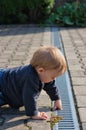 Boy dipping finger in gutter Royalty Free Stock Photo