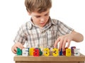 Boy displays wooden figures in form of numerals Royalty Free Stock Photo