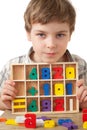 Boy displays wooden figures in form of numerals