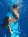 boy diving in pool with transparent water and blue background