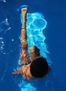 boy diving in pool with transparent water and blue background