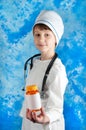 Boy in doctor costume holding bottle with pills