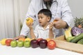 A boy and doctor happy to have healthy food. Kid learning about nutrition with doctor to choose eating fresh fruits and vegetables Royalty Free Stock Photo