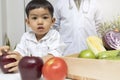 A boy and doctor happy to have healthy food. Kid learning about nutrition with doctor to choose eating fresh fruits and vegetables Royalty Free Stock Photo