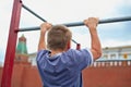 Boy does chin-ups against kremlin wall