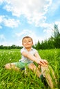 Boy does gymnastics while sitting on a meadow Royalty Free Stock Photo