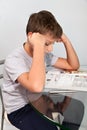 Boy does his homework on a glass table Royalty Free Stock Photo