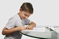 Boy does his homework on a glass table Royalty Free Stock Photo