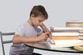 Boy does his homework with a pen in hand Royalty Free Stock Photo