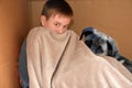 Boy and dog cuddling in a box Royalty Free Stock Photo