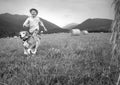 Boy and dog run together on the field with haystacks Royalty Free Stock Photo