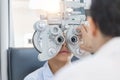 Boy doing eye test checking examination with optometrist in optical shop, Optometrist doing sight testing for child patient in Royalty Free Stock Photo