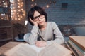 Boy is doing homework for school surrounded by books at night at home. Royalty Free Stock Photo