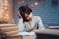 Boy is doing homework surrounded by books at night at home. Royalty Free Stock Photo