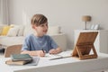 Boy doing homework with tablet at table Royalty Free Stock Photo