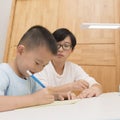 Boy doing homework with tutorship Royalty Free Stock Photo