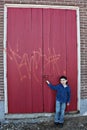 Boy by doors with graffiti Royalty Free Stock Photo