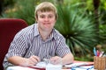 Boy with down syndrome at desk outdoors. Royalty Free Stock Photo