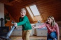 Boy with Down syndrome with his mother vacuum cleaning at home