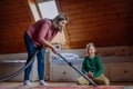 Boy with Down syndrome with his mother vacuum cleaning at home