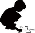 A boy drawing a picture to the ground, silhouette vector Royalty Free Stock Photo