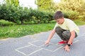 The boy draws on the pavement with chalk in the park. Games in the park Royalty Free Stock Photo