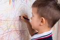 Boy draws on the wall with colored chalk. The child is engaged in creativity at home Royalty Free Stock Photo