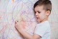 Boy draws on the wall with colored chalk. The child is engaged in creativity at home Royalty Free Stock Photo