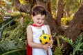 A boy dressed in a red cape holding a make-believe magic staff