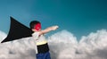 The boy dressed up in a superhero outfit, pretending to flying on the sky background. Royalty Free Stock Photo