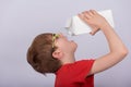 Boy drinking milk or juice from pack, white background. Copy space. Template. Mockup