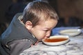 The boy drinks tea from a saucer A resident of the tundra indigenous residents of the Far North